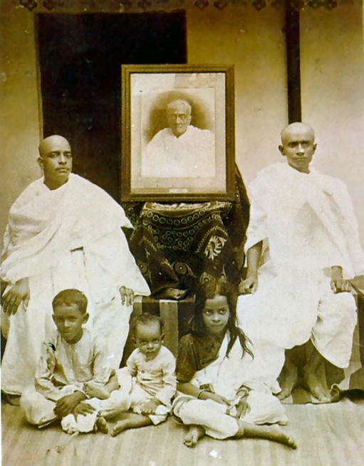 C.	 A. C. Bhaktivedanta Swami Prabhupadaâ€™s Family, From Left Swami Prabhupada (Sitting), Portrait of His Father Gaur Mohan De (Middle), His Brother Krishna Charan (Sitting), His Son Prayag Raj (Sitting Frontside Left), His Second Son (Sitting Middle), His Daughter Sulakshman (Sitting Frontside Right)   